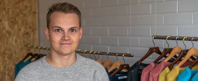 Alpa representative standing in front of a clothing rack