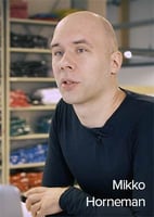 Mikko from Lumingerie in an interview, sitting in front of warehouse shelves
