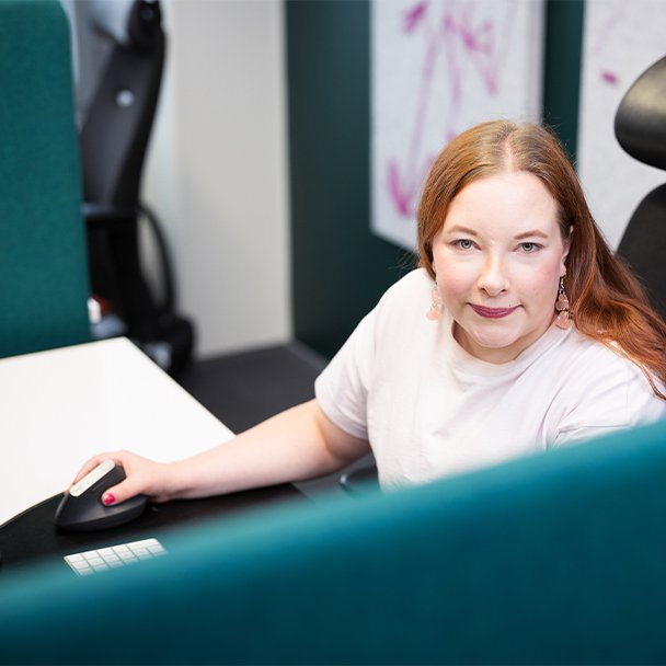 Woman working at a desk and smiling at the camera