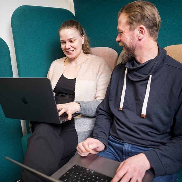 Two people working on laptops