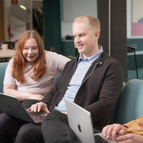 Two people collaborating on a laptop, representing teamwork