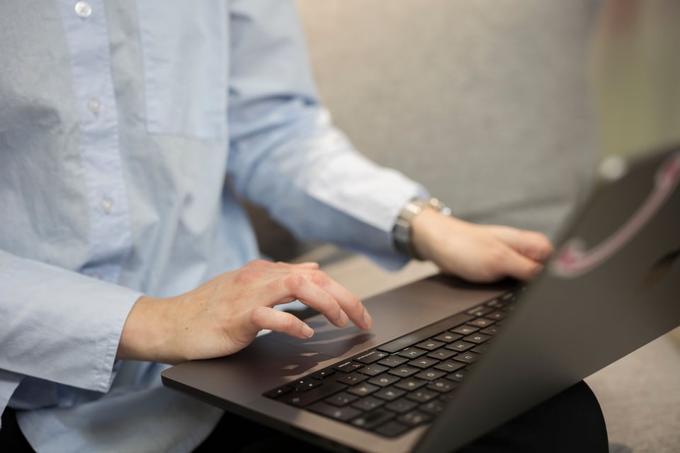 Hands typing on a laptop keyboard