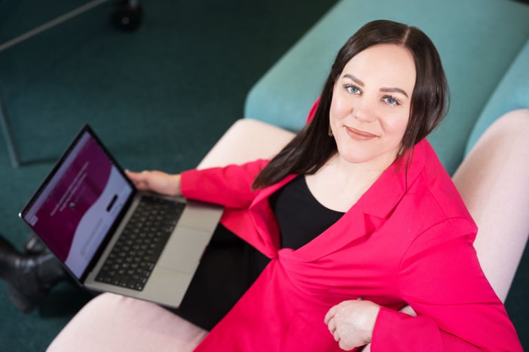 Woman sitting with a laptop and looking at the camera