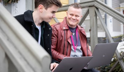 Kaksi miestä läppärit sylissään