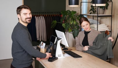 Mies vaatekaupan kassalla