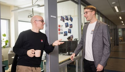 Kaksi miestä keskustelemassa toimistolla